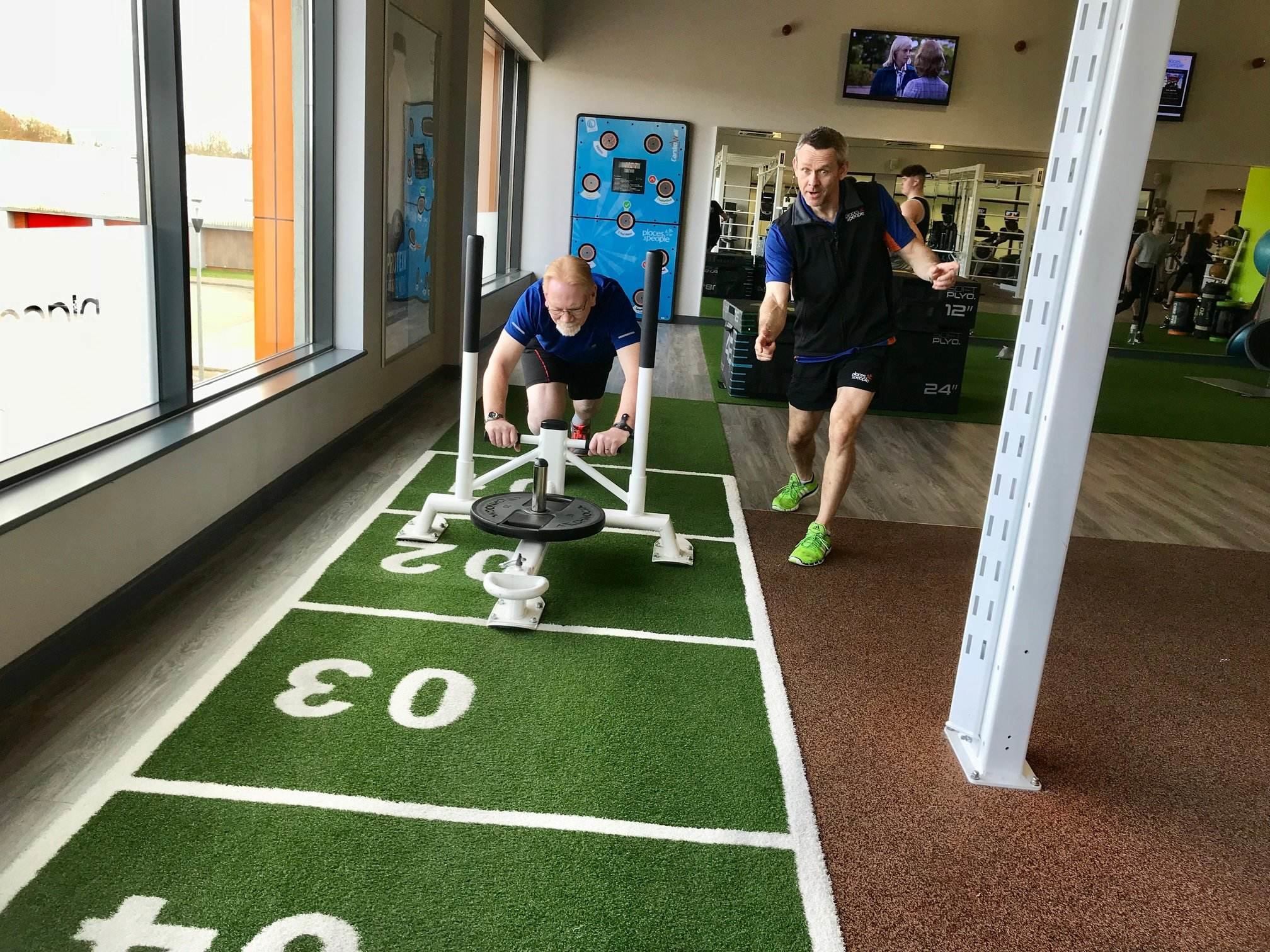 paul pushing sled in gym with steve